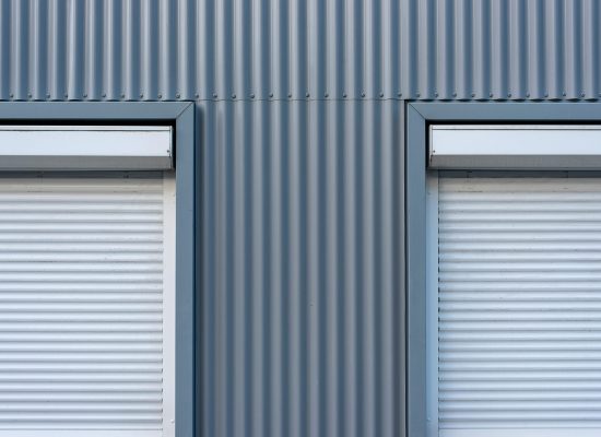 pexels-photo-32563446-32563446 Dual industrial-style roller blinds on a corrugated metal wall for a sleek, modern look.
